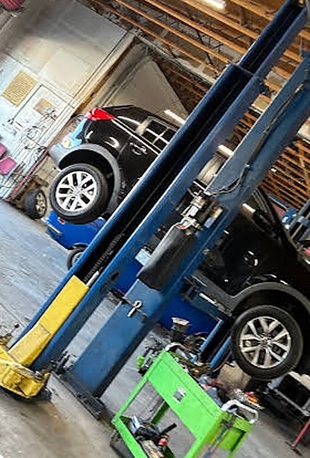 Service bay with vehicles on two-post lifts